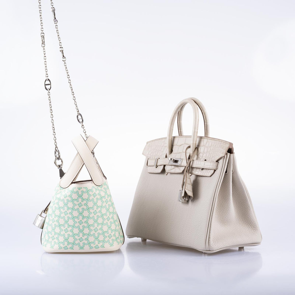 Hermès Birkin 25 Touch Béton in three-quarter view at right, beside a small pale green patterned handbag on a chain, the patterned handbag and chain sold separately.