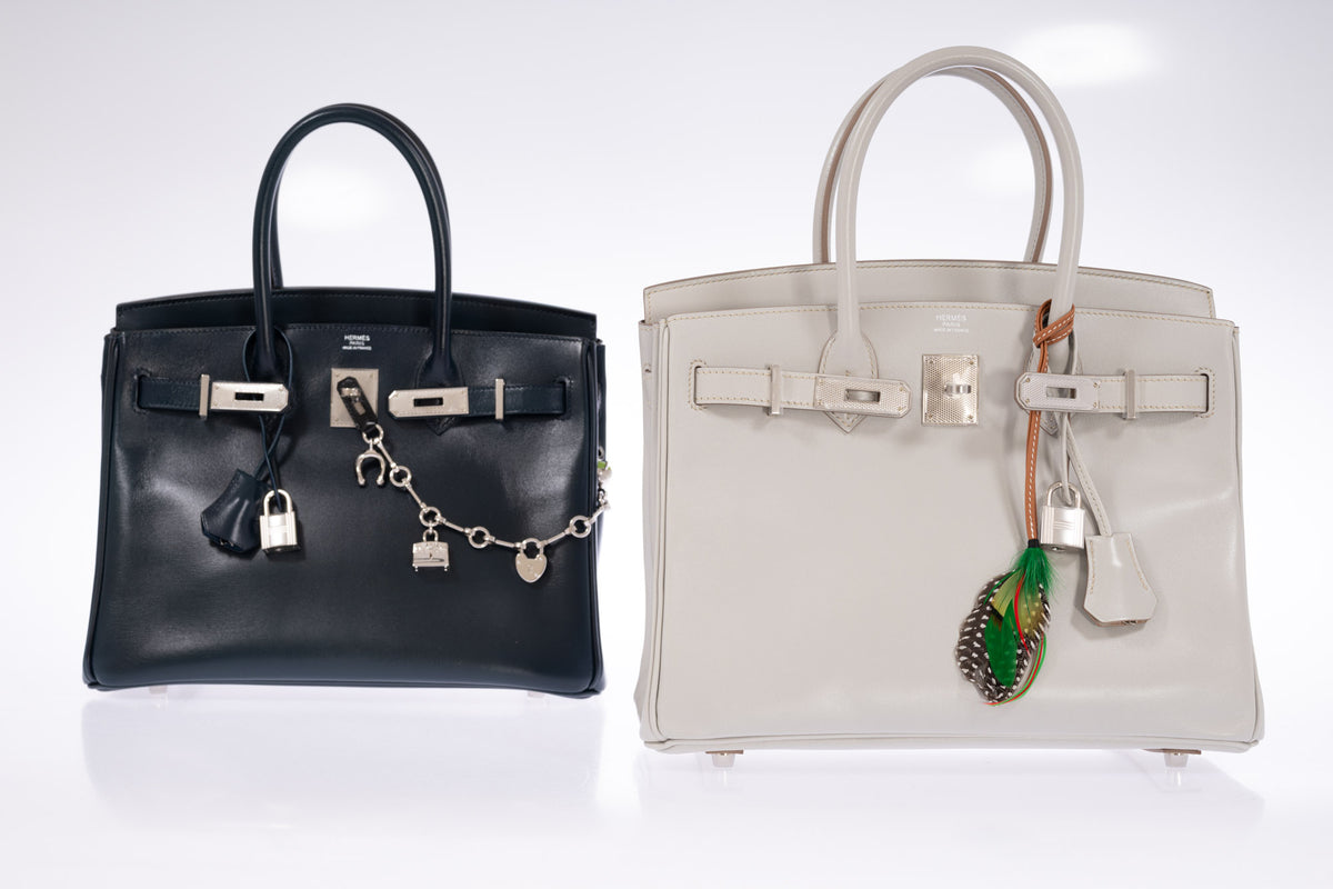 Hermès Birkin 30 Bleu de Prusse Box Calf Guilloche Palladium Hardware, shown at left with a charm chain beside a Birkin 30 Gris Perle with a feather charm, all sold separately