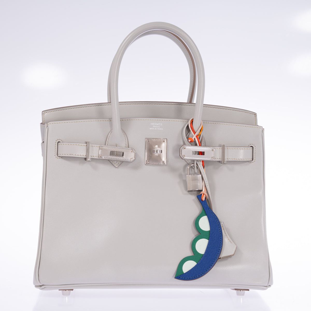 Hermès Birkin 30 Gris Perle Box Calf Guilloche Palladium Hardware, front view with the flap open, styled with a blue and green pea pod charm, sold separately