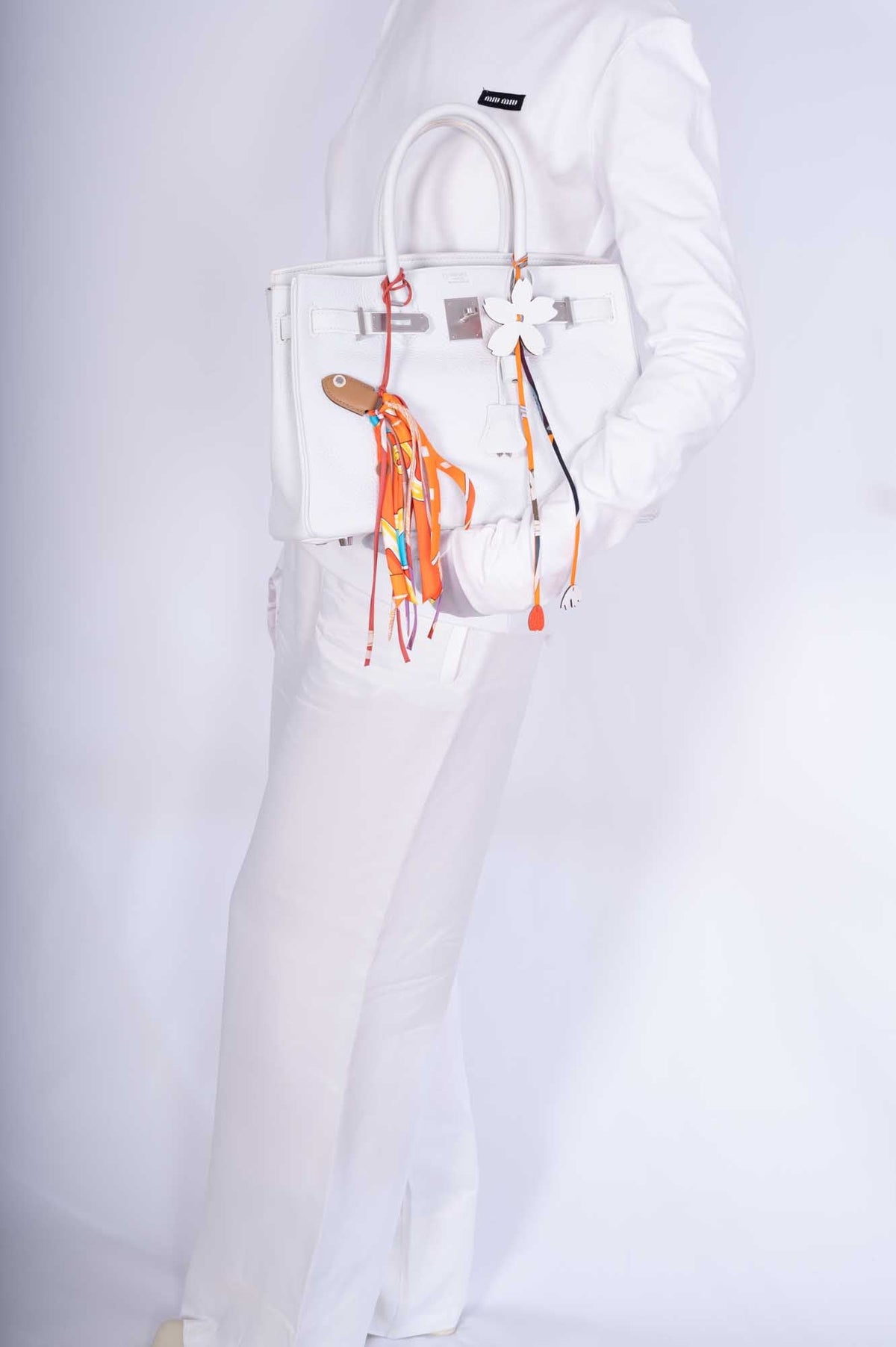 Hermès Birkin 30 HSS White Clemence Brushed Palladium Hardware, carried by a model, side view, shown with charms and a twilly that are not included