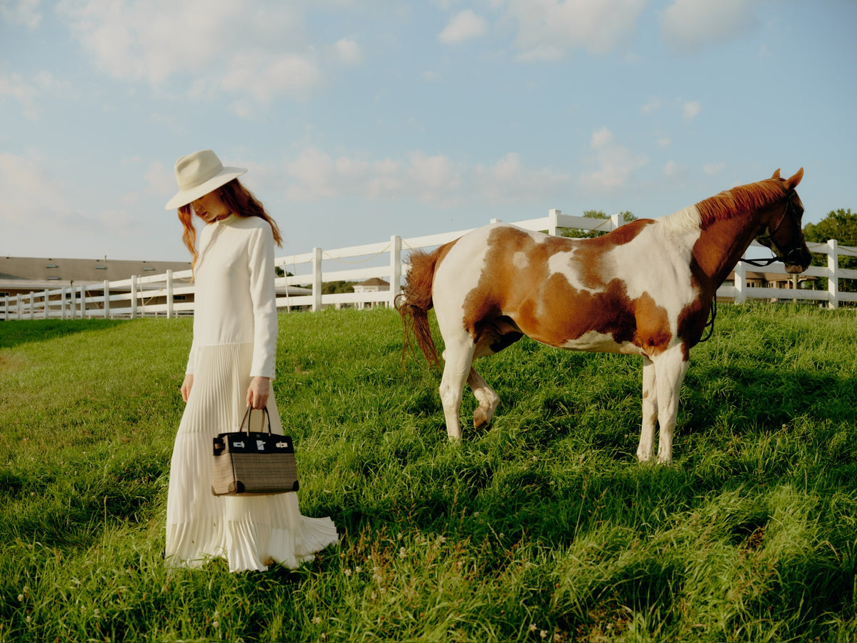 Hermès Birkin 30 Lainage Houndstooth Wool and Ébène Togo Palladium Hardware, carried by a model in a paddock with a horse