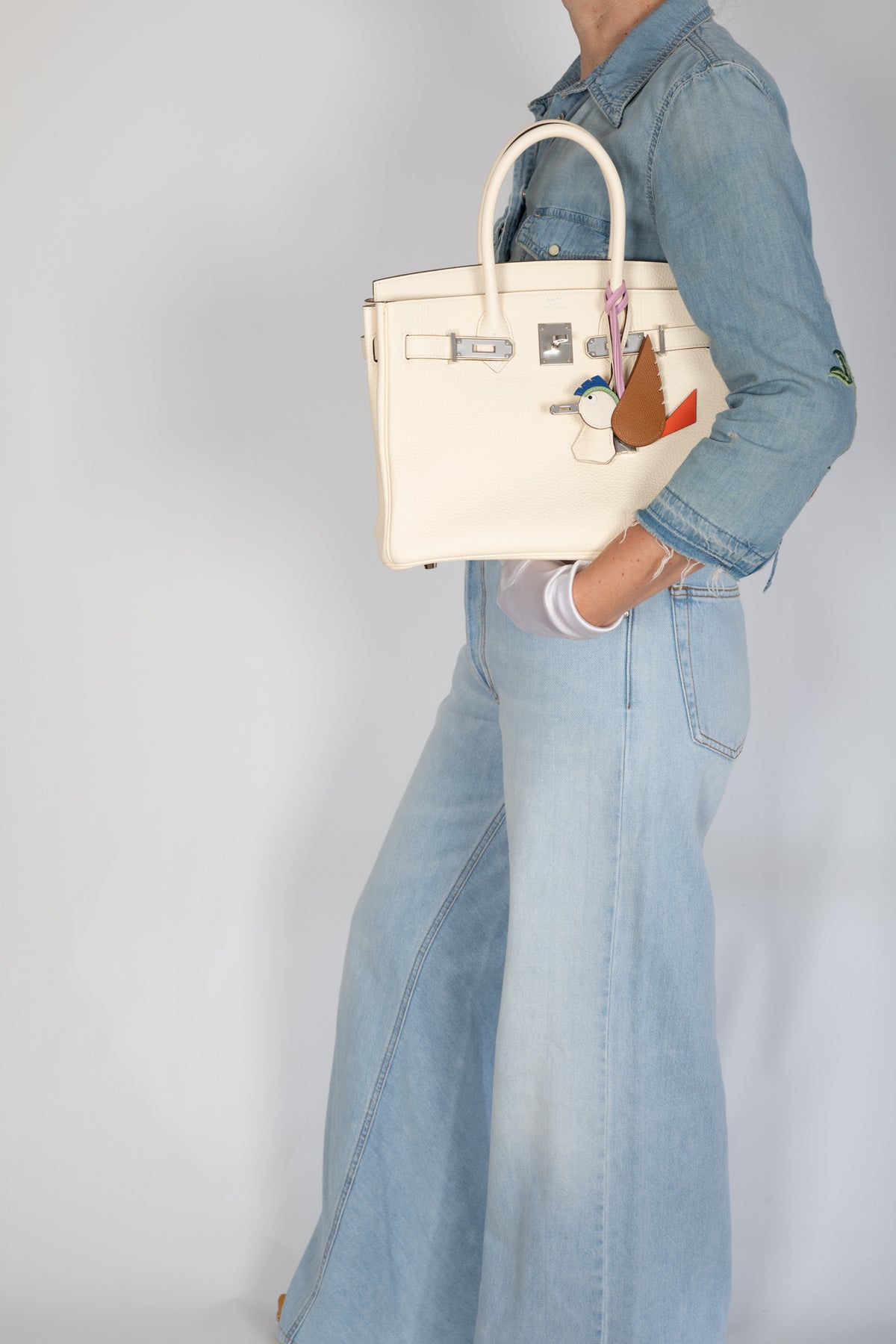 Hermès Birkin 30 Nata Togo Palladium Hardware, carried under the arm with the flap open, styled with a bird charm, sold separately