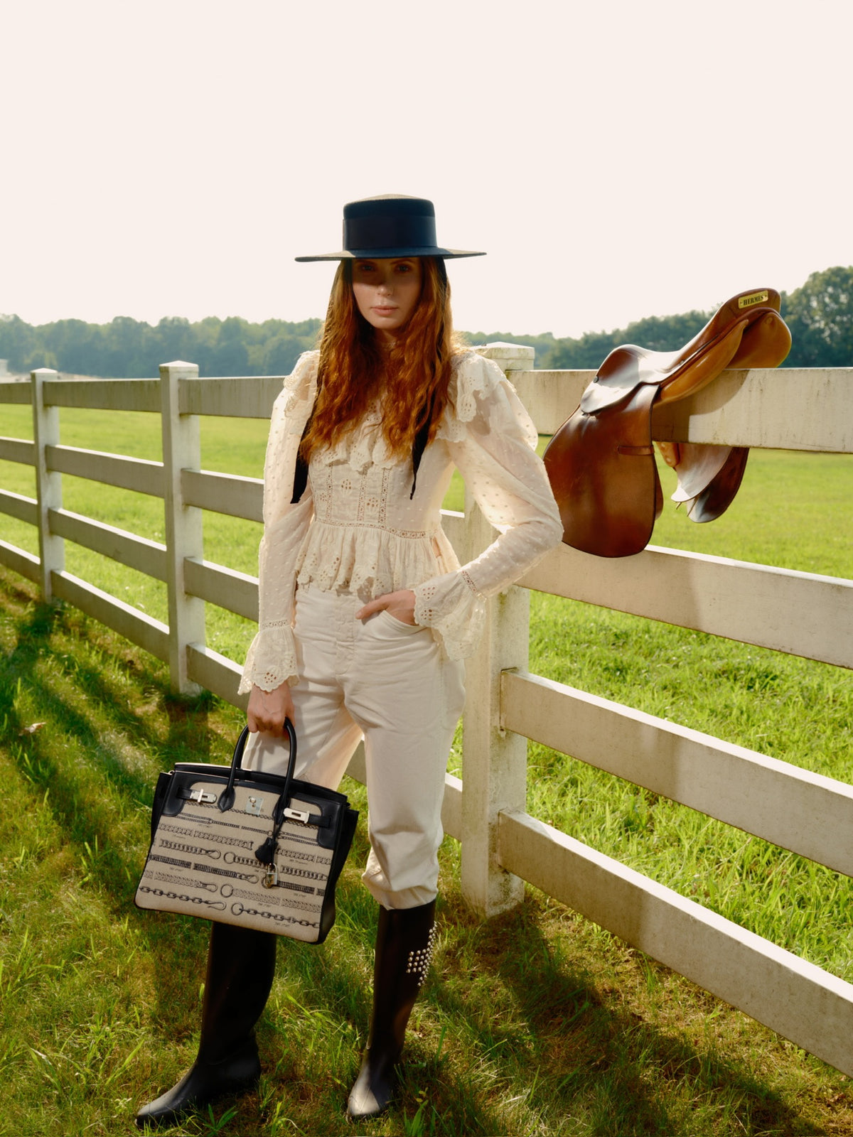 Hermès Birkin 35 De Camp Déchaînée Toile and Black Veau Swift Palladium Hardware, carried by a model at a paddock fence with a saddle