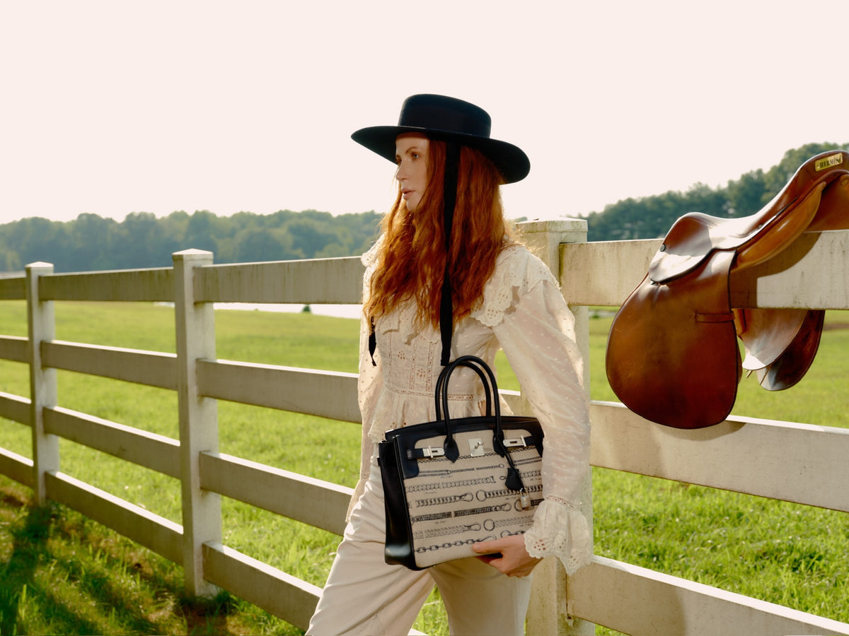 Hermès Birkin 35 De Camp Déchaînée Toile and Black Veau Swift Palladium Hardware, held by a model at a fence, side view