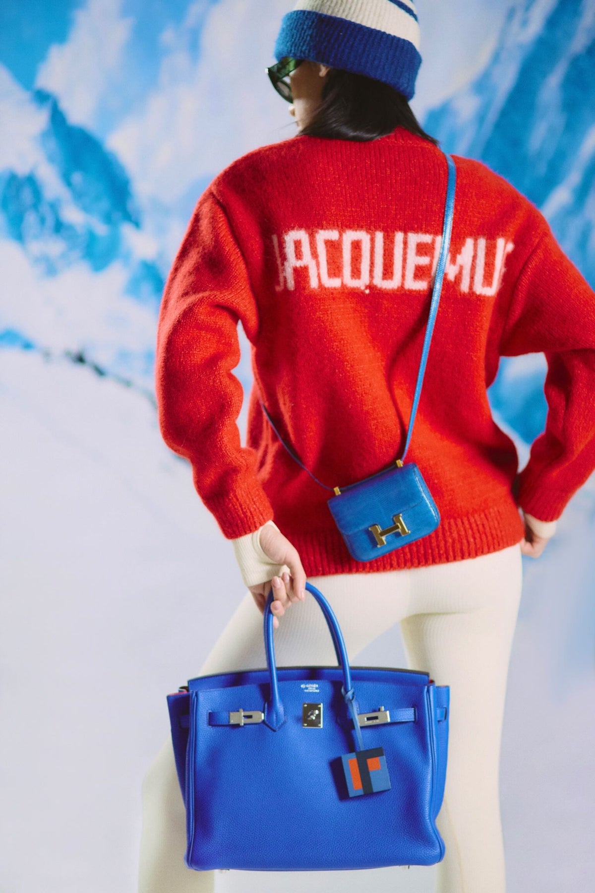 Hermès Birkin 35 HSS Bleu Electrique / Fuchsia Interior Togo Palladium Hardware, carried by the handles by a model wearing a blue mini Constance