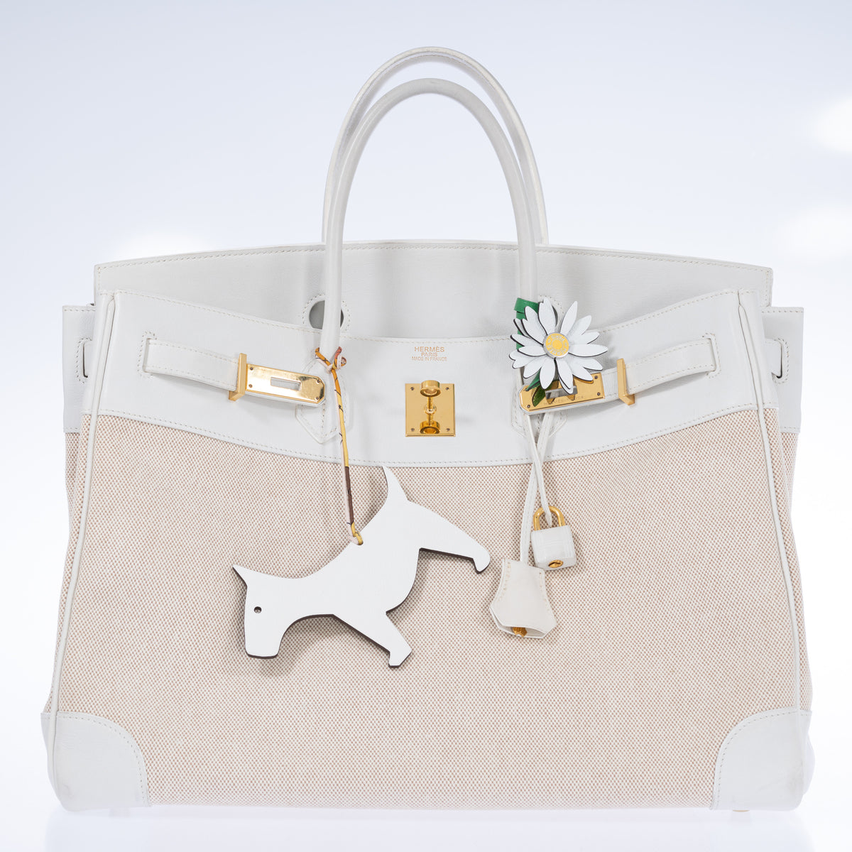 Hermès Birkin 40 Toile and Blanc Swift Gold Hardware, front view with the flap open, styled with a white leather daisy charm and a white leather animal charm on a printed twilly, sold separately