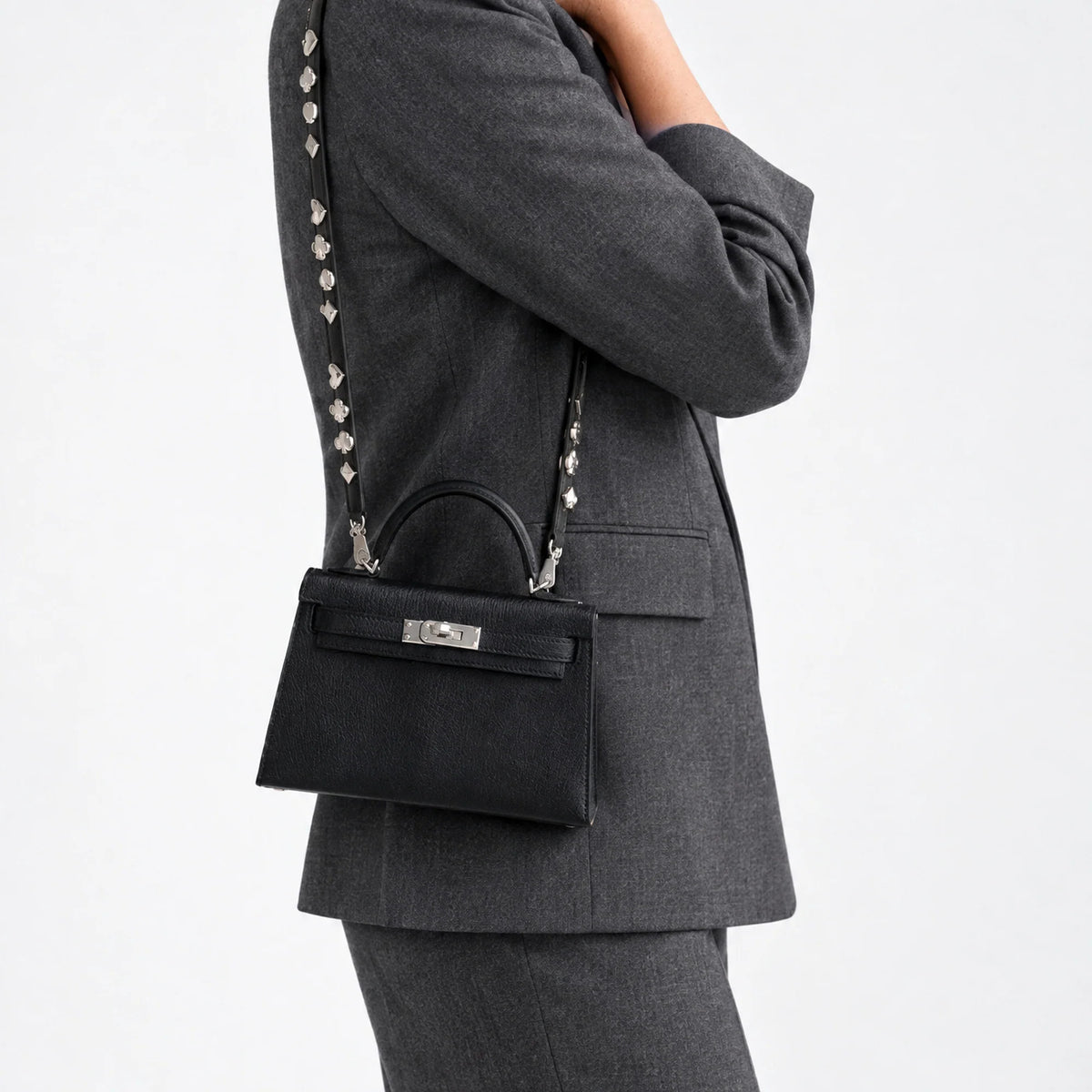Hermès Clou de Coeur Kelly 20 Mini II Sellier Noir Chèvre Chamkila Palladium Hardware, worn on the shoulder with the studded strap