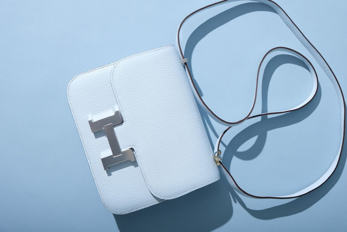 Hermès Constance 18 Blue Brume Chèvre Palladium Hardware, flat lay with its strap