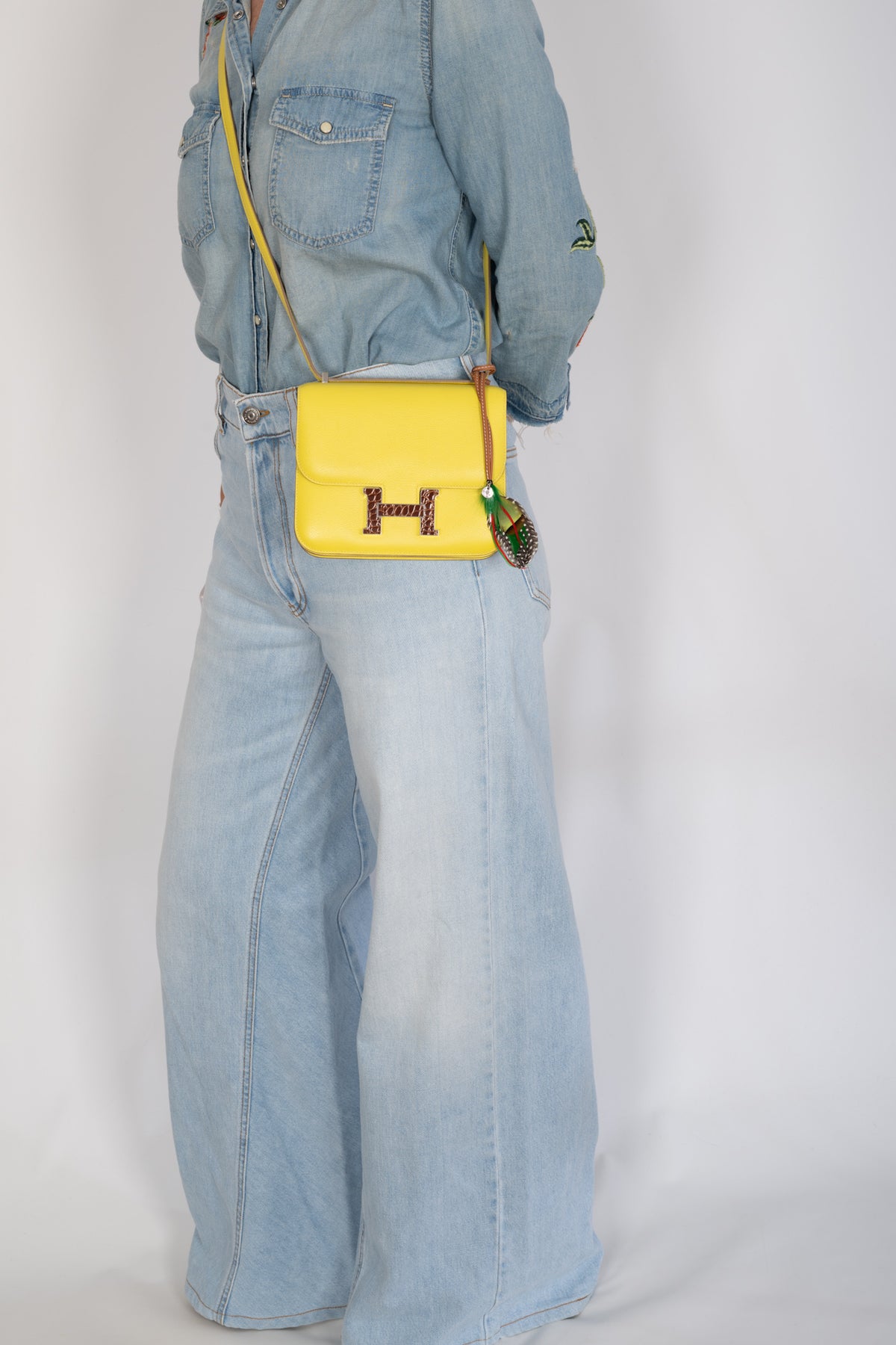Hermès Constance 18 Mini Lime Evergrain Miel Alligator Buckle Palladium Hardware, worn crossbody by a model, full-length view, shown with a charm that is not included
