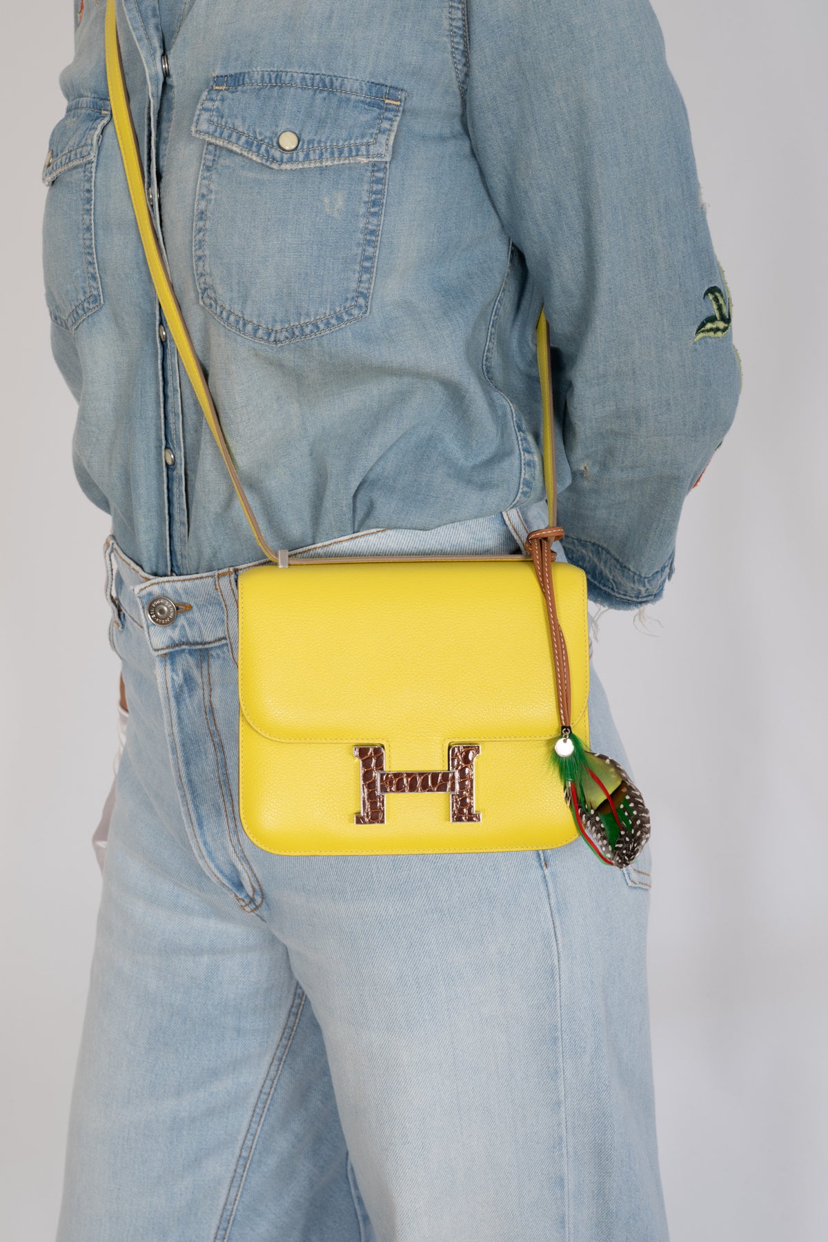 Hermès Constance 18 Mini Lime Evergrain Miel Alligator Buckle Palladium Hardware, worn crossbody by a model, shown with a charm that is not included