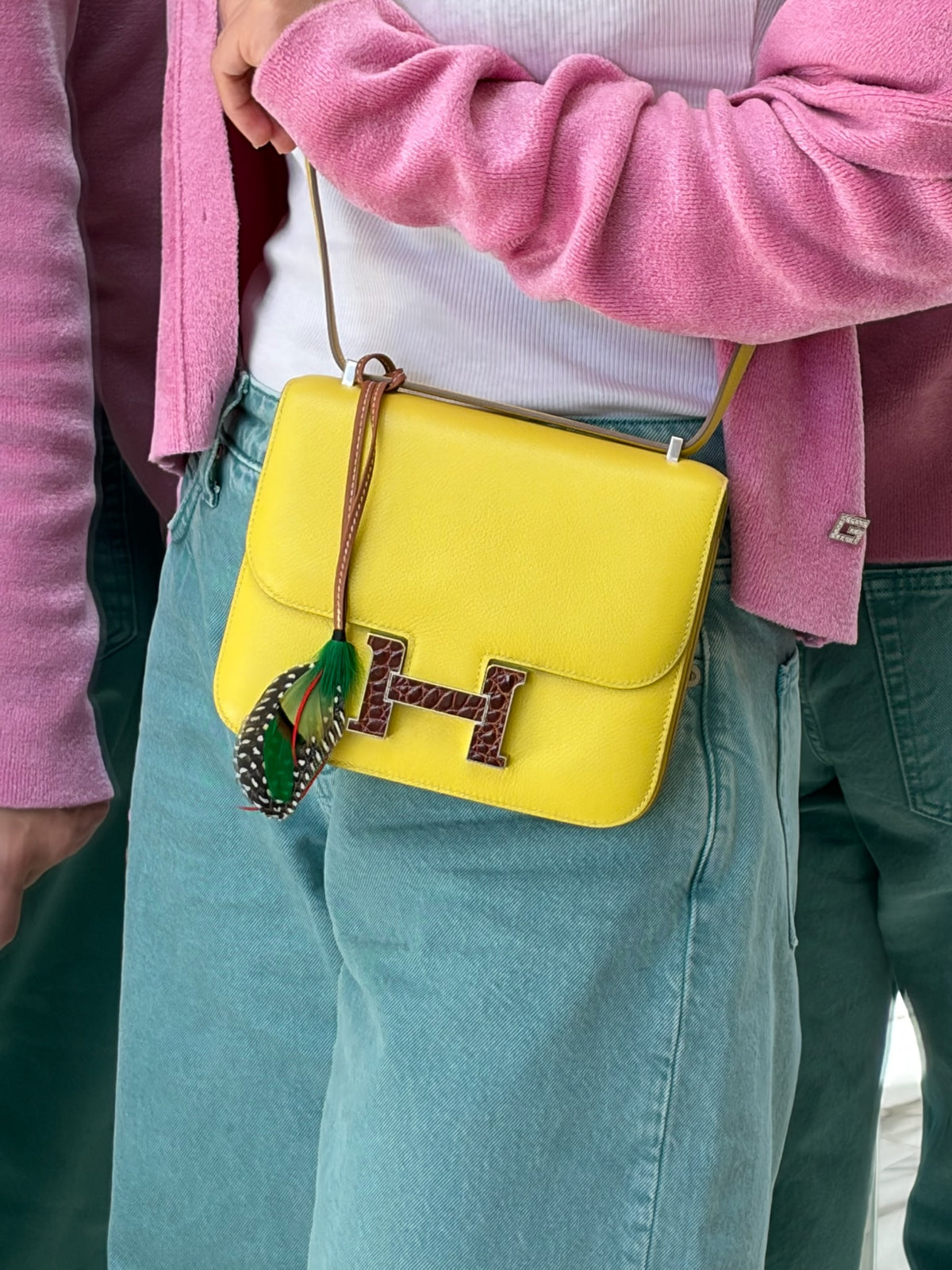 Hermès Constance 18 Mini Lime Evergrain Miel Alligator Buckle Palladium Hardware, worn crossbody by a model, close view, shown with a charm that is not included