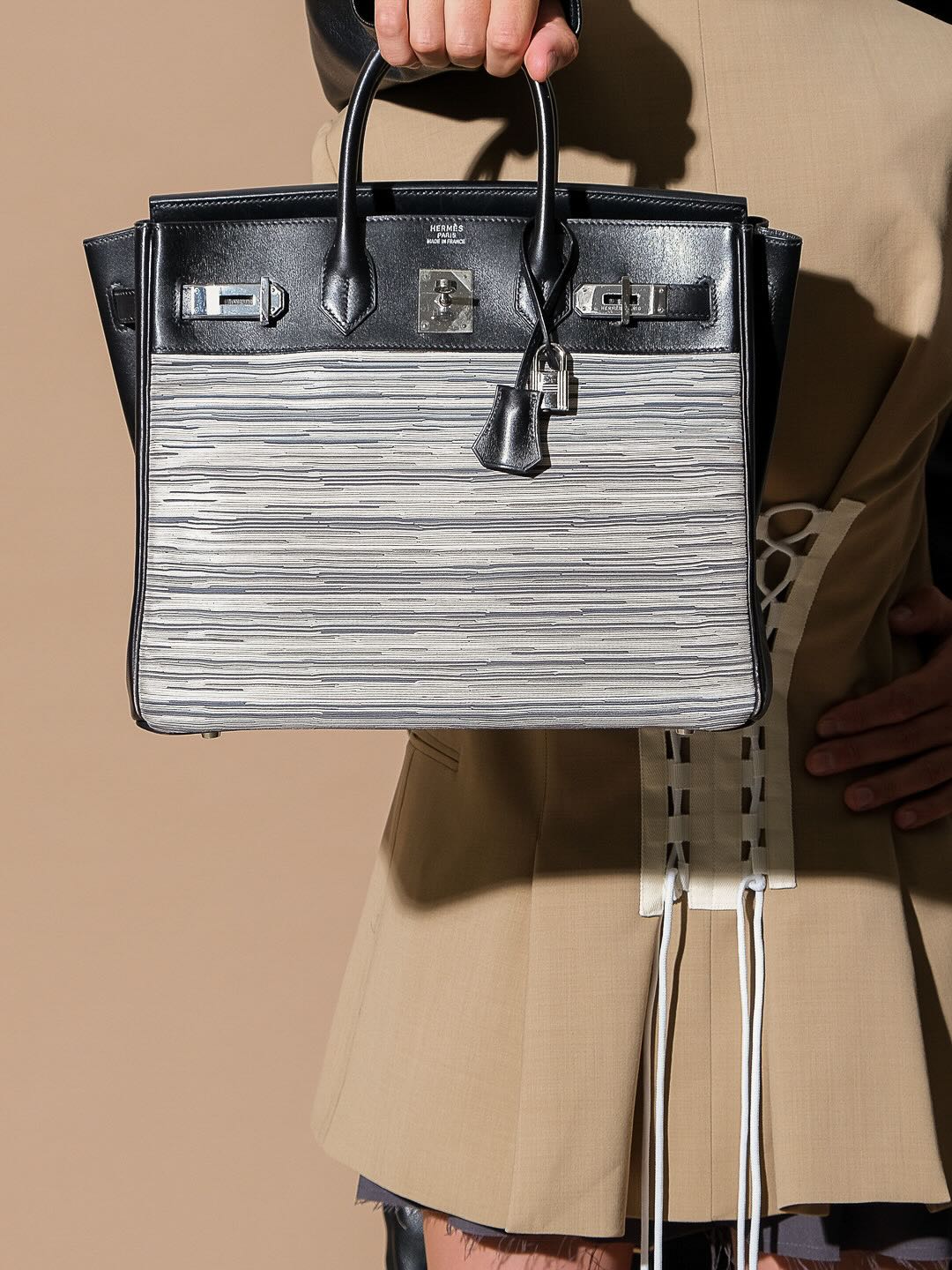 Hermès HAC Birkin 32 Vibrato and Noir Box Calf Palladium Hardware, carried by the handles by a model, close view