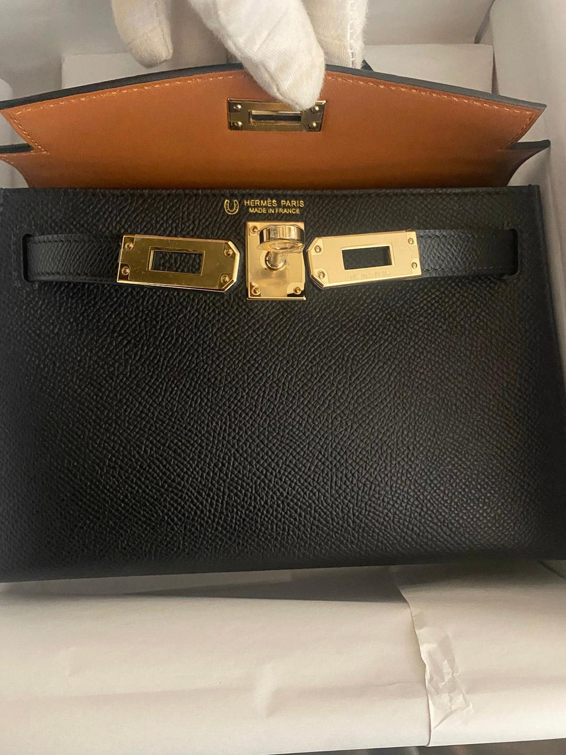 Hermès Kelly 20 Mini II HSS Verso, close-up showing the horseshoe stamp beside the Hermès heat stamp, Permabrass turn-lock and strap-end plates on Noir Epsom leather.