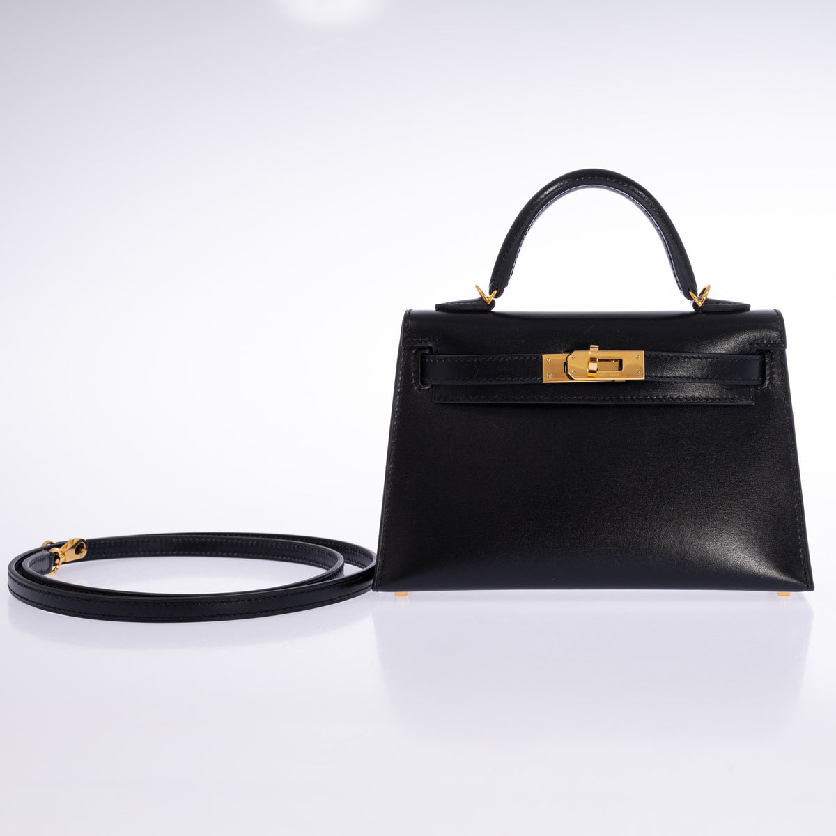 Hermès Kelly 20 Mini II Sellier in Noir Box calf with gold hardware, front view with detachable leather shoulder strap.