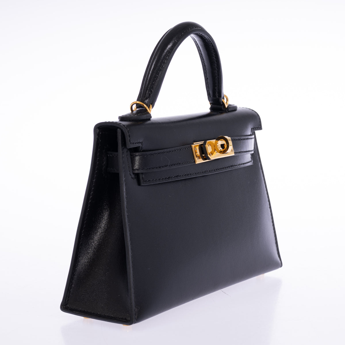 Hermès Kelly 20 Mini II Sellier in Noir Box calf with gold hardware, three-quarter view showing the side gusset and external stitching.