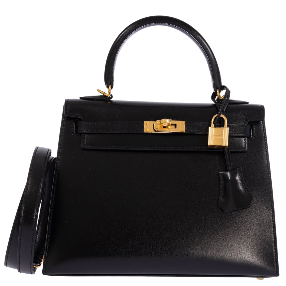 Hermès Kelly 25 Sellier in Noir Box calf with gold hardware, front view with leather shoulder strap, padlock and clochette.