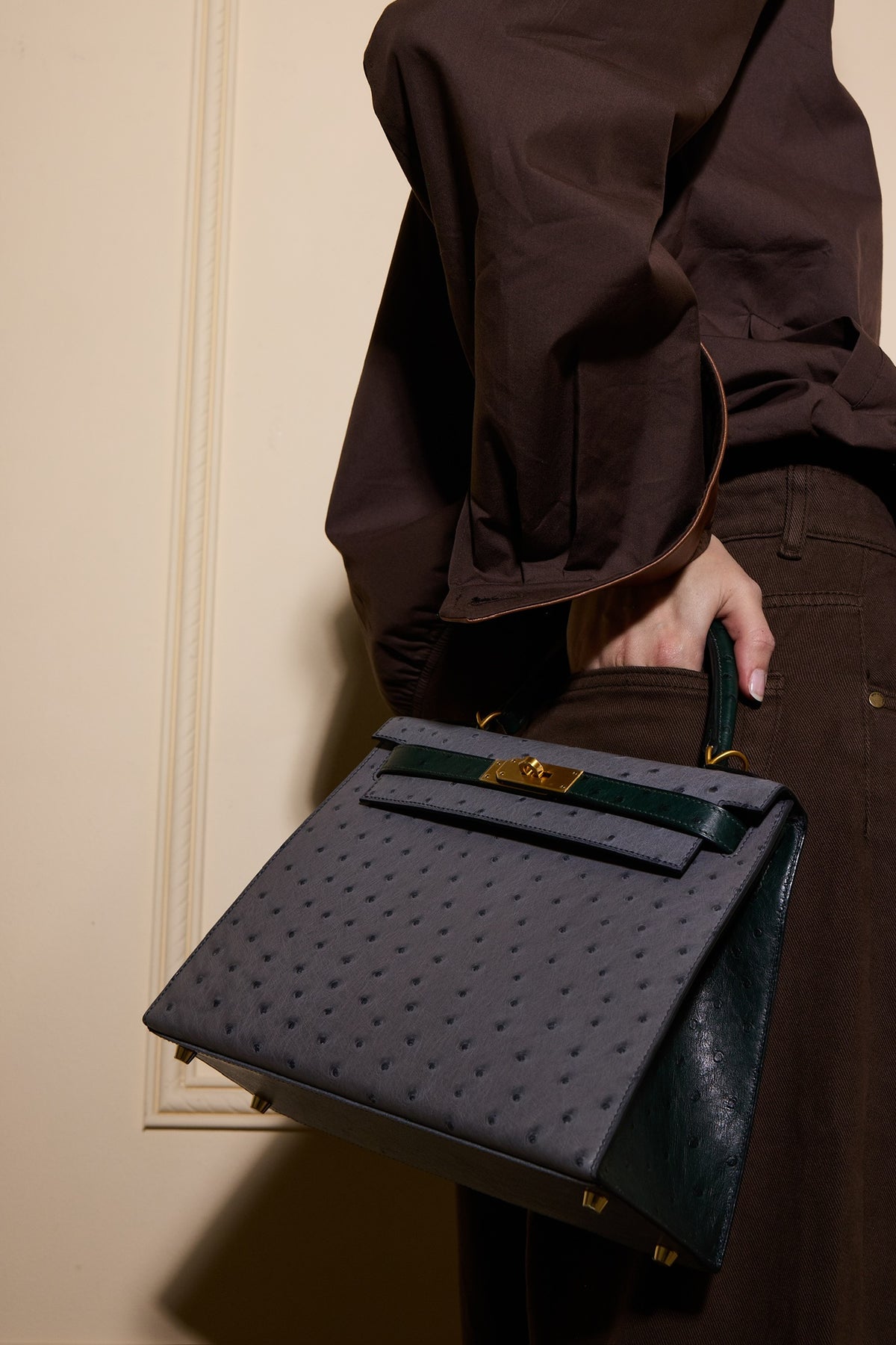 Hermès Kelly 28 Sellier HSS Gris Agate/Vert Titien Ostrich Brushed Gold Hardware, carried by a model, hand in pocket