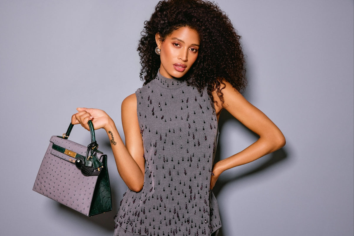 Hermès Kelly 28 Sellier HSS Gris Agate/Vert Titien Ostrich Brushed Gold Hardware, held out by a model