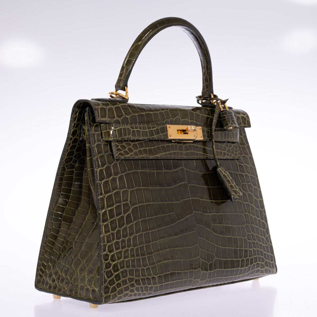 Hermès Kelly 28 Sellier Vert Véronèse shiny Niloticus crocodile with gold hardware, three-quarter view showing the left side, lock and clochette.