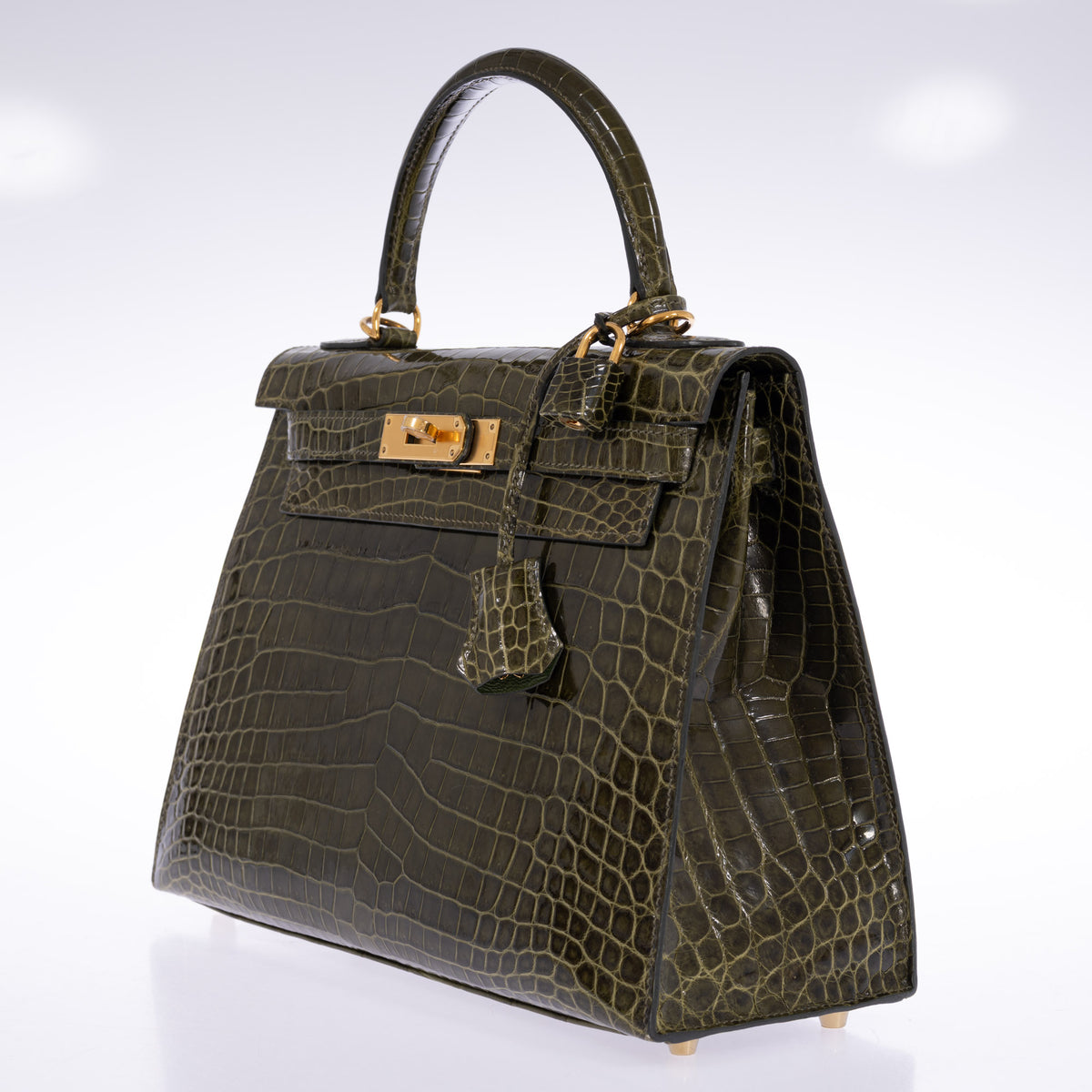 Hermès Kelly 28 Sellier Vert Véronèse shiny Niloticus crocodile with gold hardware, three-quarter view showing the right side, lock and clochette.