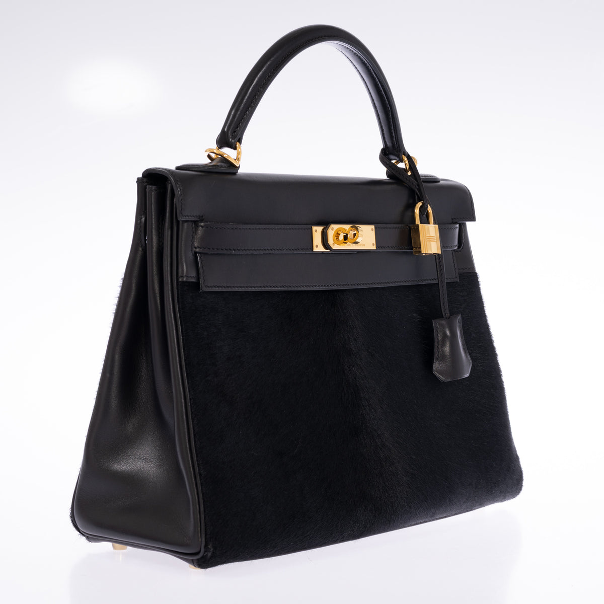 Hermès Kelly 32 Noir Box leather and pony skin with Gold hardware, three-quarter front view showing the left gusset.