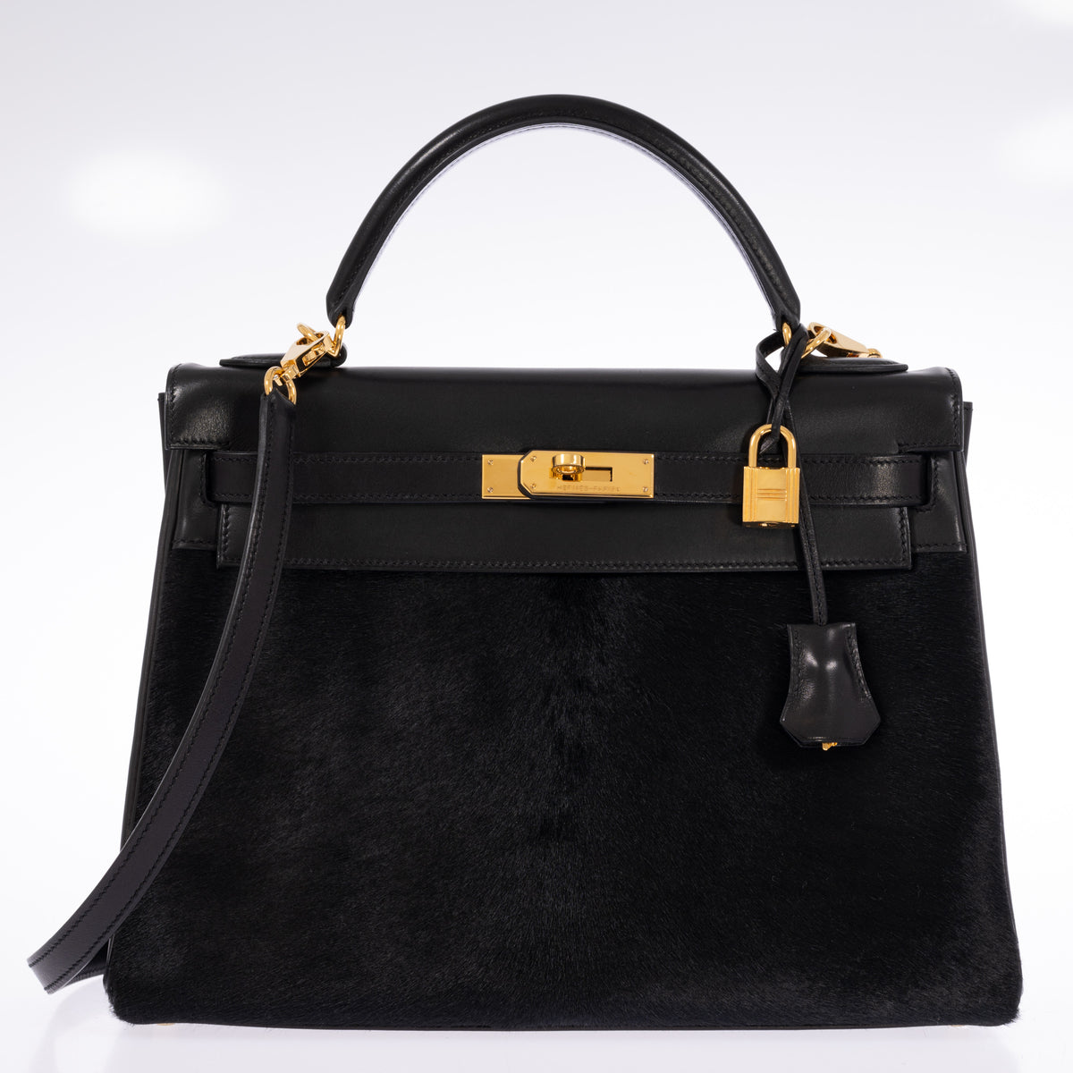 Hermès Kelly 32 Noir Box leather and pony skin with Gold hardware, closed front view with the shoulder strap attached.