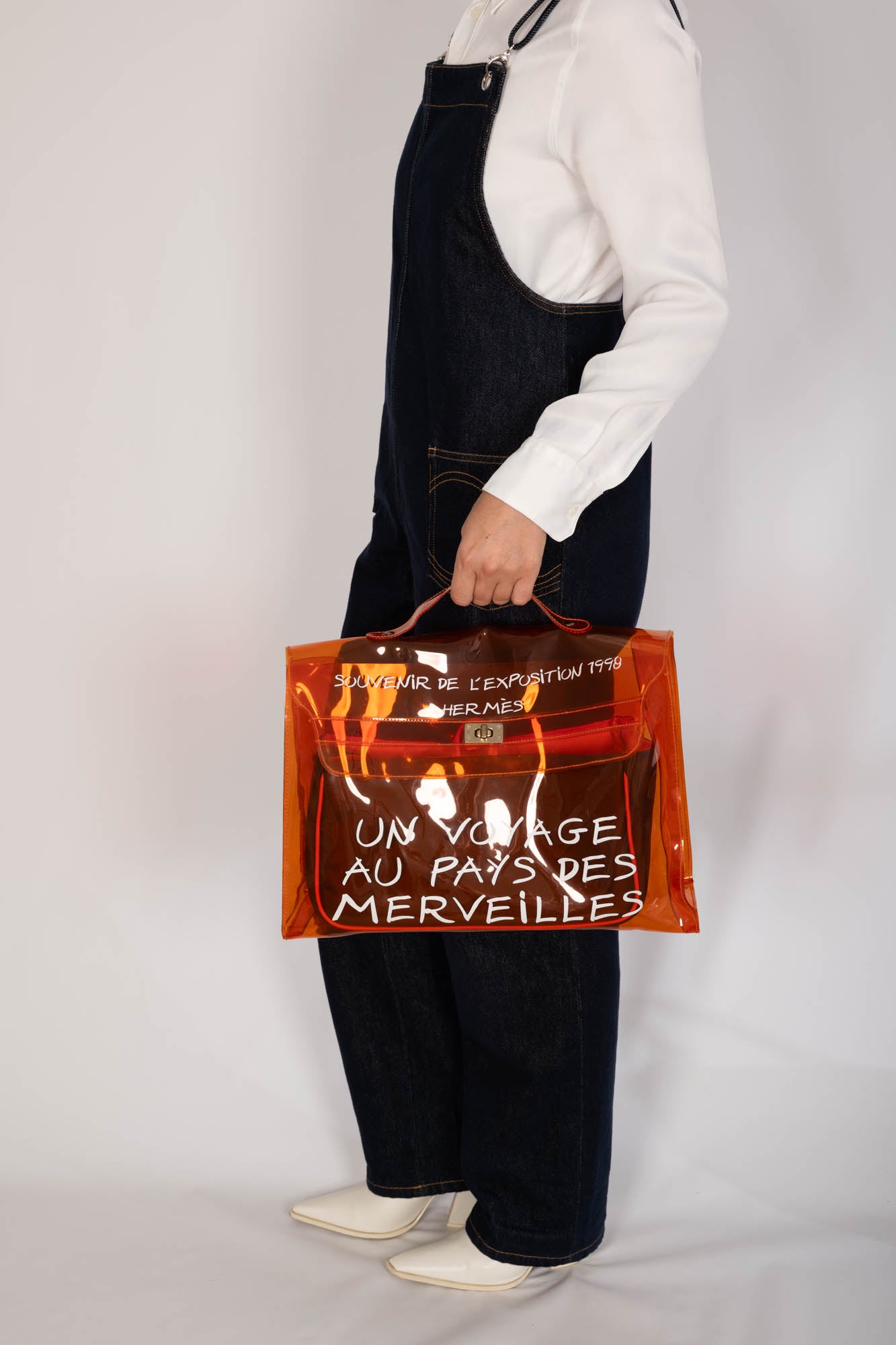 Hermès Kelly 40 Orange Translucent Vinyl Souvenir de l'Exposition 1998 bag carried by hand