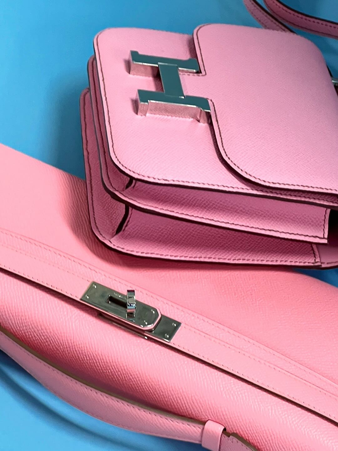 Hermès Kelly Cut Rose Confetti Epsom leather Palladium Hardware, flat lay close view of the turn lock beside a pink Constance