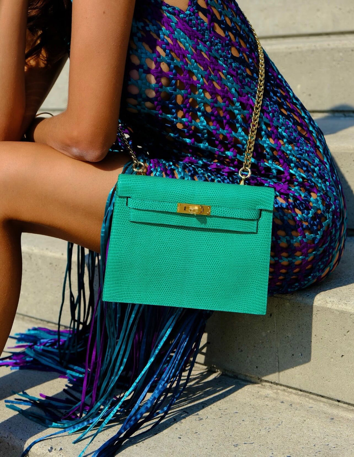 Hermès Kelly Danse II Menthe Shiny Nilo Lizard Gold Hardware, worn on a chain by a seated model, close view
