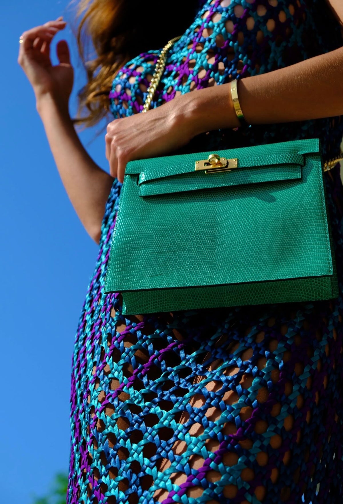 Hermès Kelly Danse II Menthe Shiny Nilo Lizard Gold Hardware, worn on a chain by a model, close view