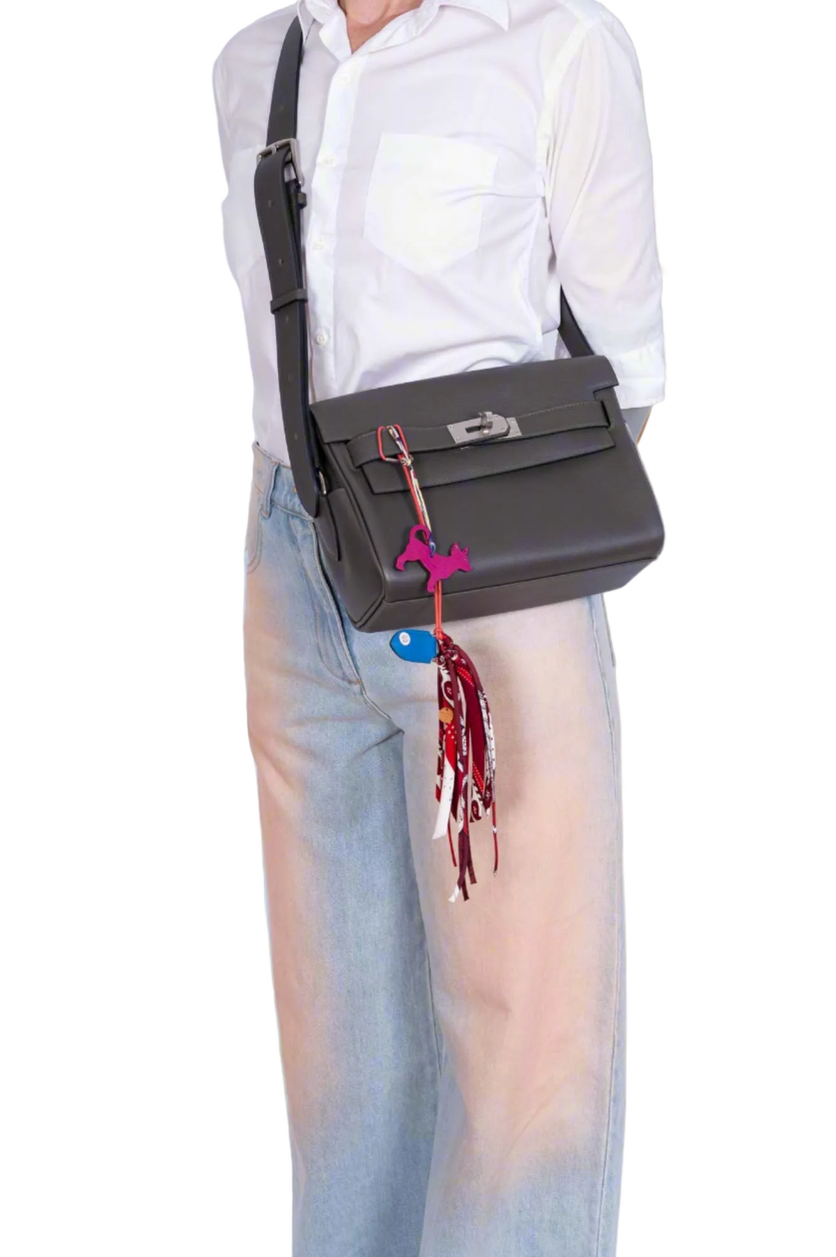 Hermès Kelly Messenger PM Gris Misty Evercolor Palladium Hardware, worn crossbody by a model, styled with a charm and a twilly, sold separately