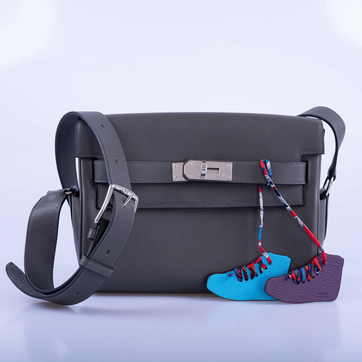 Hermès Kelly Messenger PM Gris Misty Evercolor Palladium Hardware, close front view with the strap buckle, styled with two charms, sold separately
