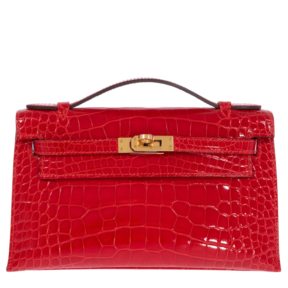 Hermès Kelly Pochette Geranium shiny alligator with gold hardware, closed front view.