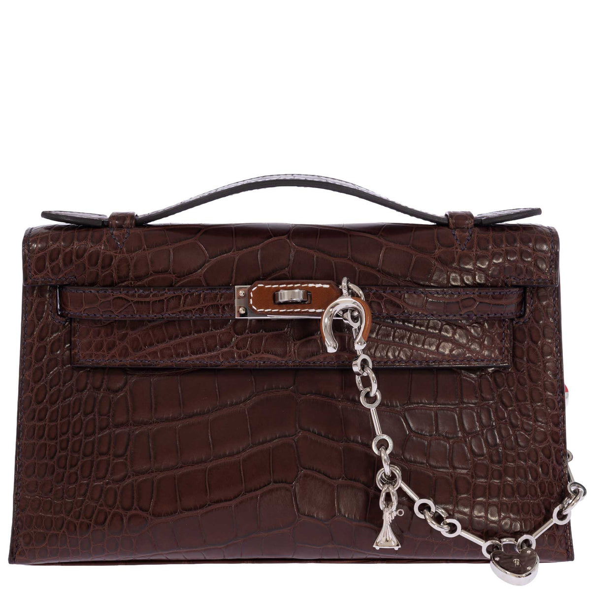 Hermès Kelly Pochette in Havane matte alligator, front view styled with a silver charm chain sold separately.