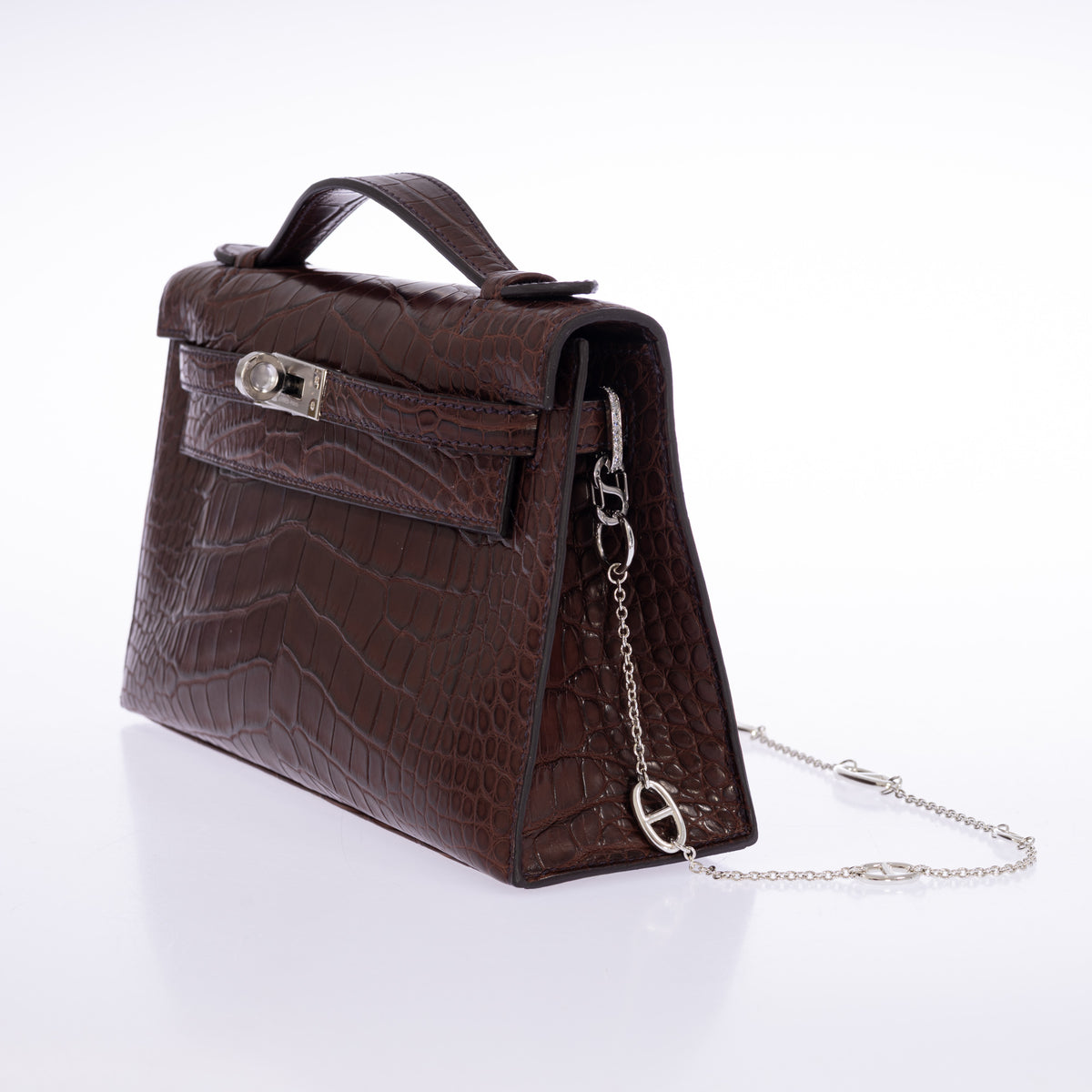 Hermès Kelly Pochette in Havane matte alligator, right three-quarter view with The Strap Converter and chain.