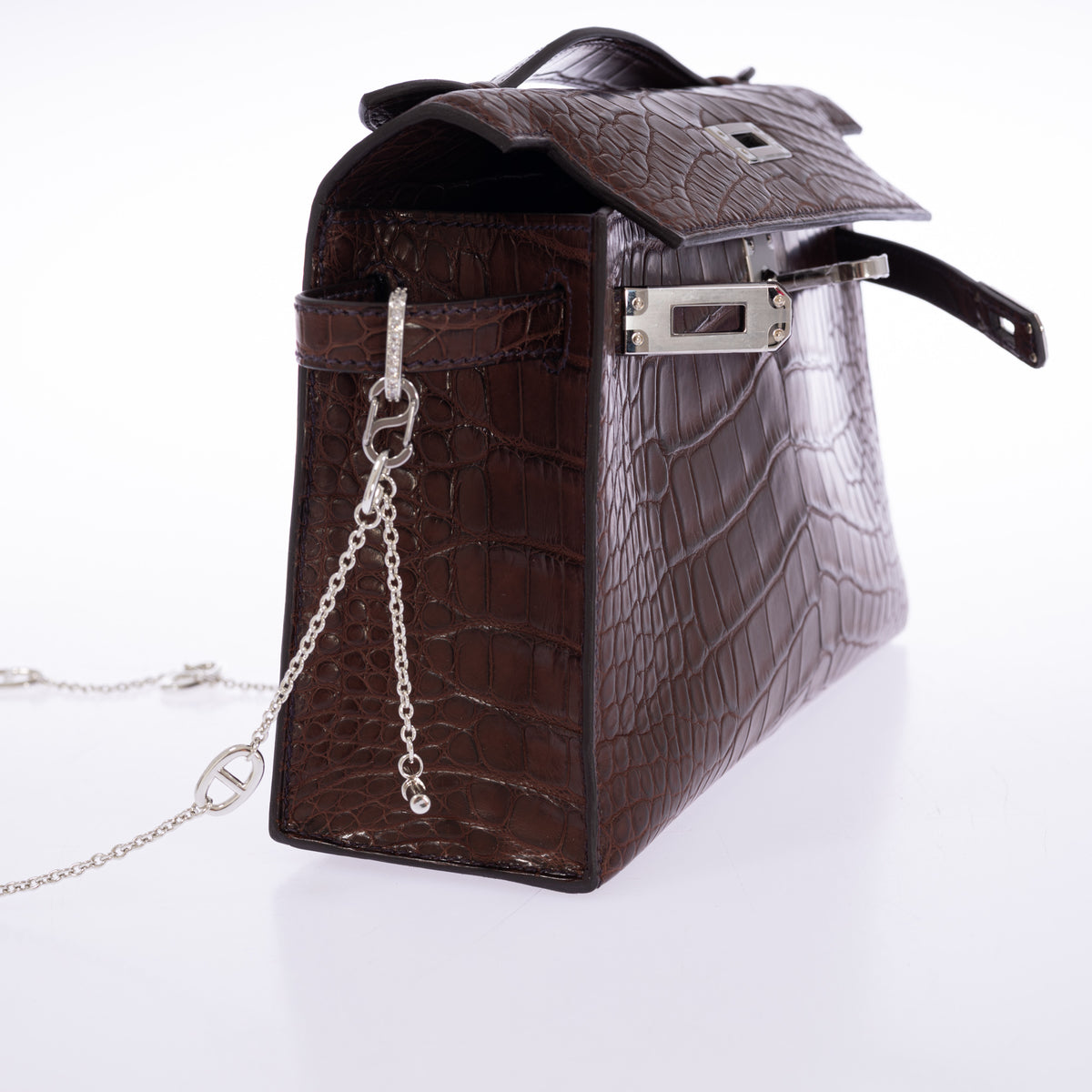 Hermès Kelly Pochette in Havane matte alligator, side view with the flap open and palladium turn-lock.