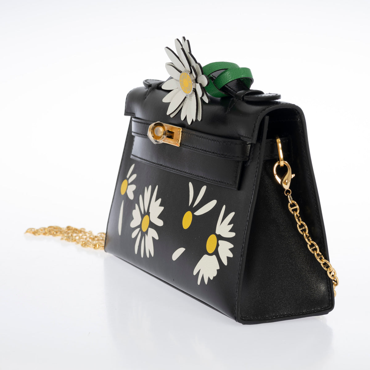 Hermès Kelly Pochette Marqueterie Marguerite Noir Box Gold Hardware, three-quarter view with a marguerite charm and shoulder chain, charm and chain sold separately
