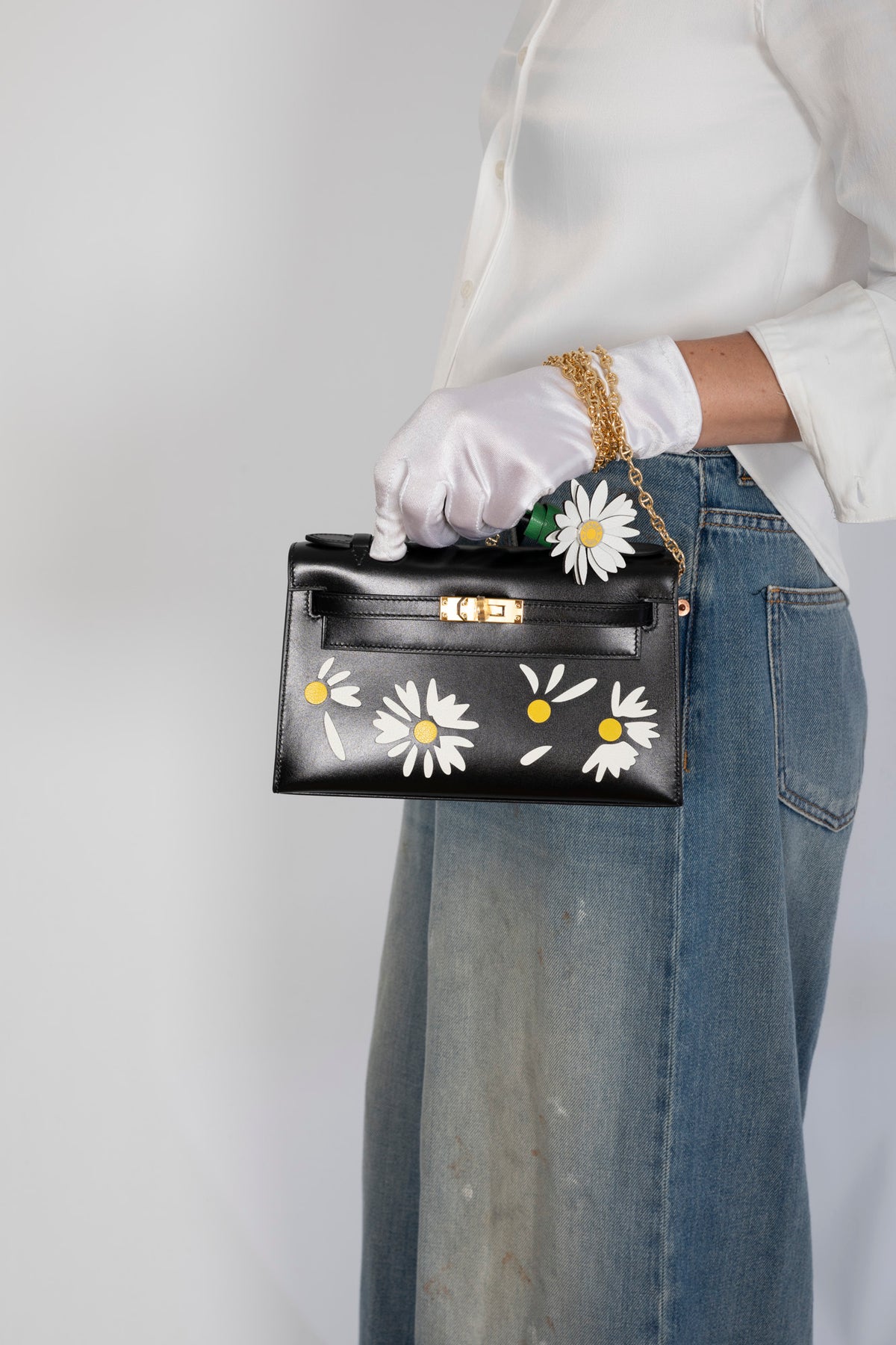 Hermès Kelly Pochette Marqueterie Marguerite Noir Box Gold Hardware, carried by a model