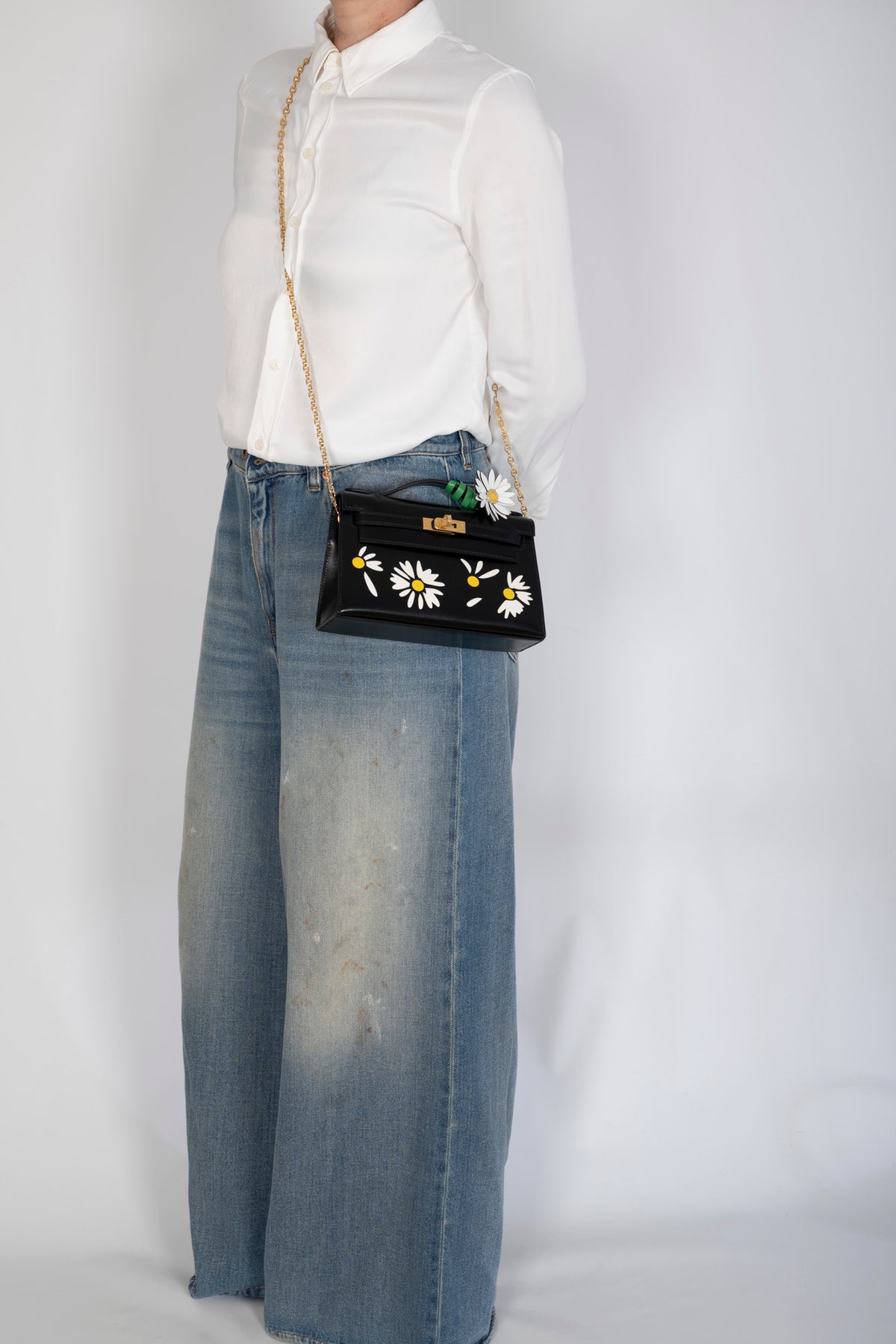 Hermès Kelly Pochette Marqueterie Marguerite Noir Box Gold Hardware, worn at the hip by a model