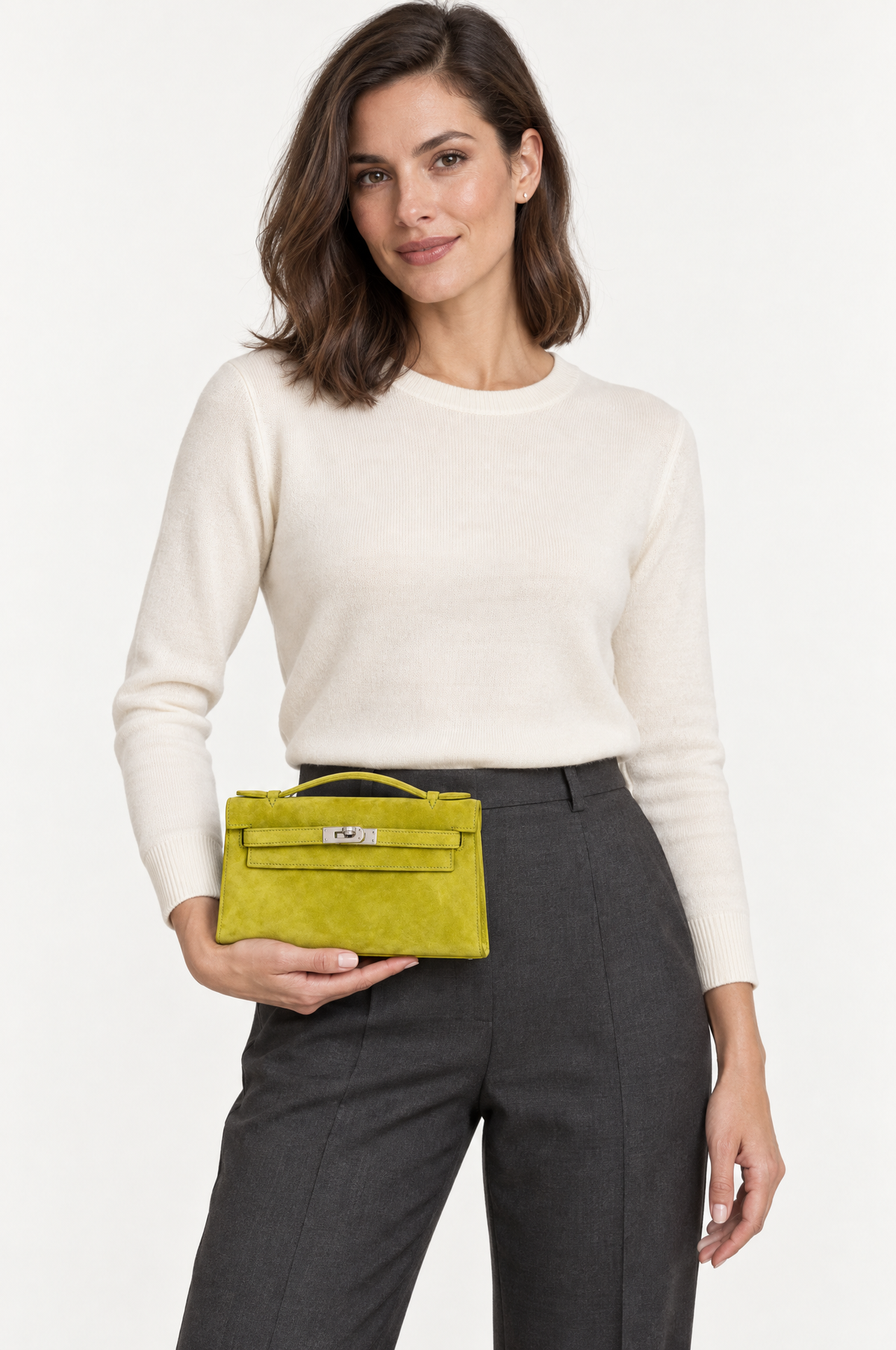 Hermès Kelly Pochette Vert Anis Veau Doblis Suede Palladium Hardware, carried by a model at the hip, front view