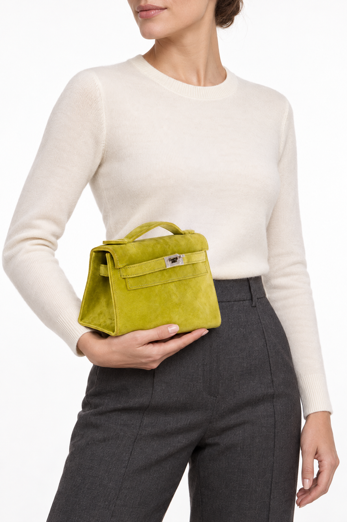 Hermès Kelly Pochette Vert Anis Veau Doblis Suede Palladium Hardware, held by a model at the hip, three-quarter close view
