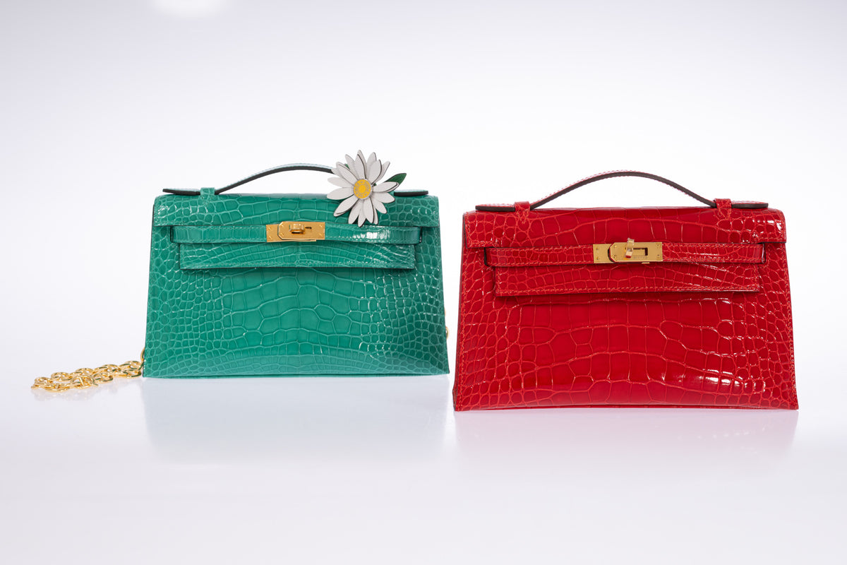Vert Jade alligator Hermès Kelly Pochette with gold hardware and daisy styling, photographed beside a red Pochette.