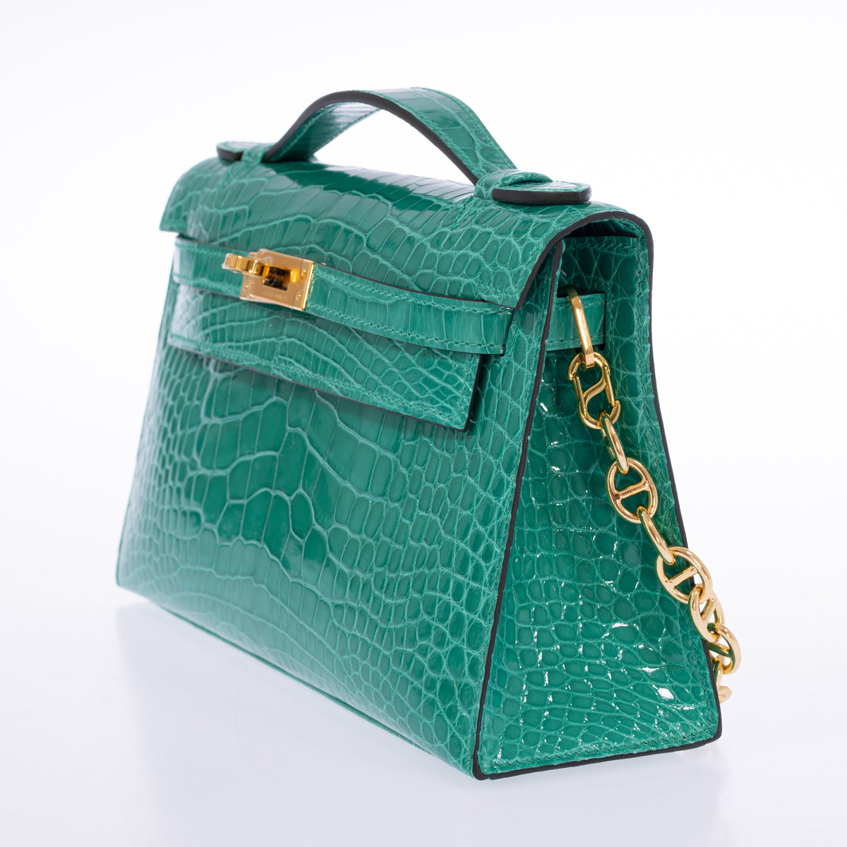 Hermès Kelly Pochette in Vert Jade shiny alligator with gold hardware, right three-quarter view with chain styling.
