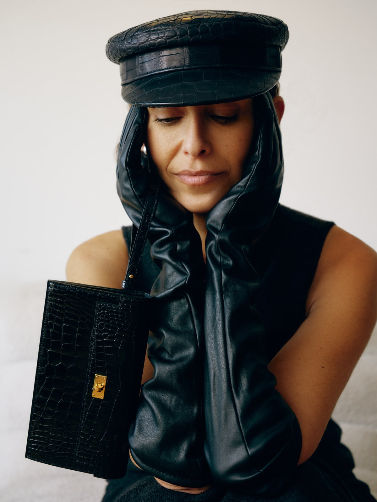 Hermès Kelly Pocket Long Wallet Black Alligator Gold Hardware, held by a model resting her chin on her hands
