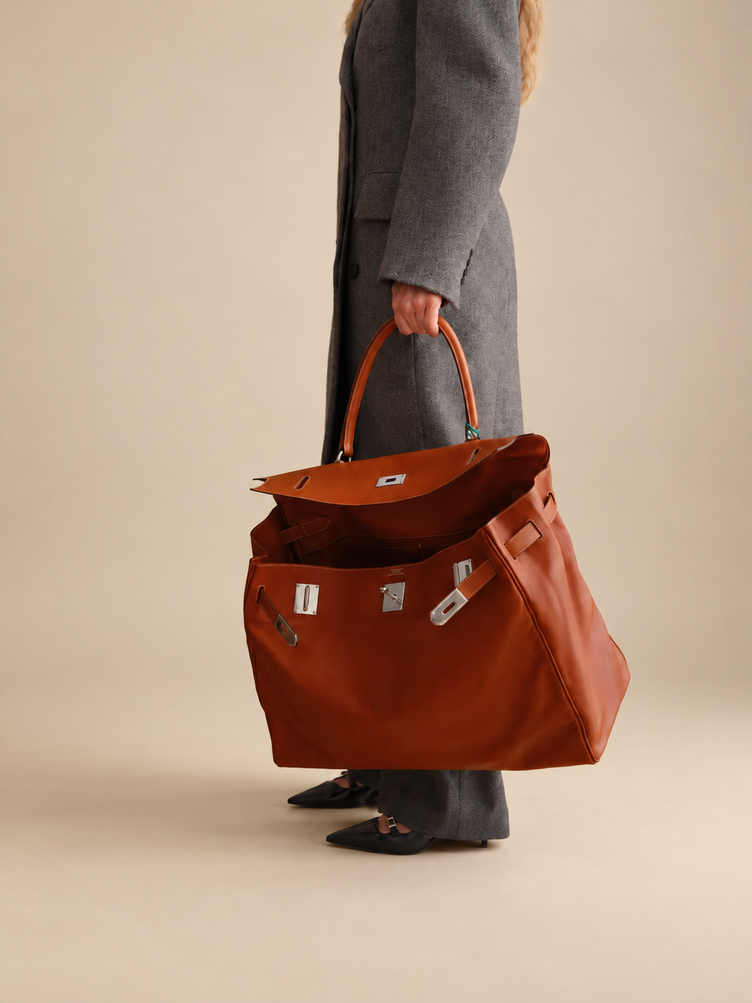 Hermès Kelly Relax 50 Fauve Swift Palladium Hardware, carried by hand with the flap open, close view