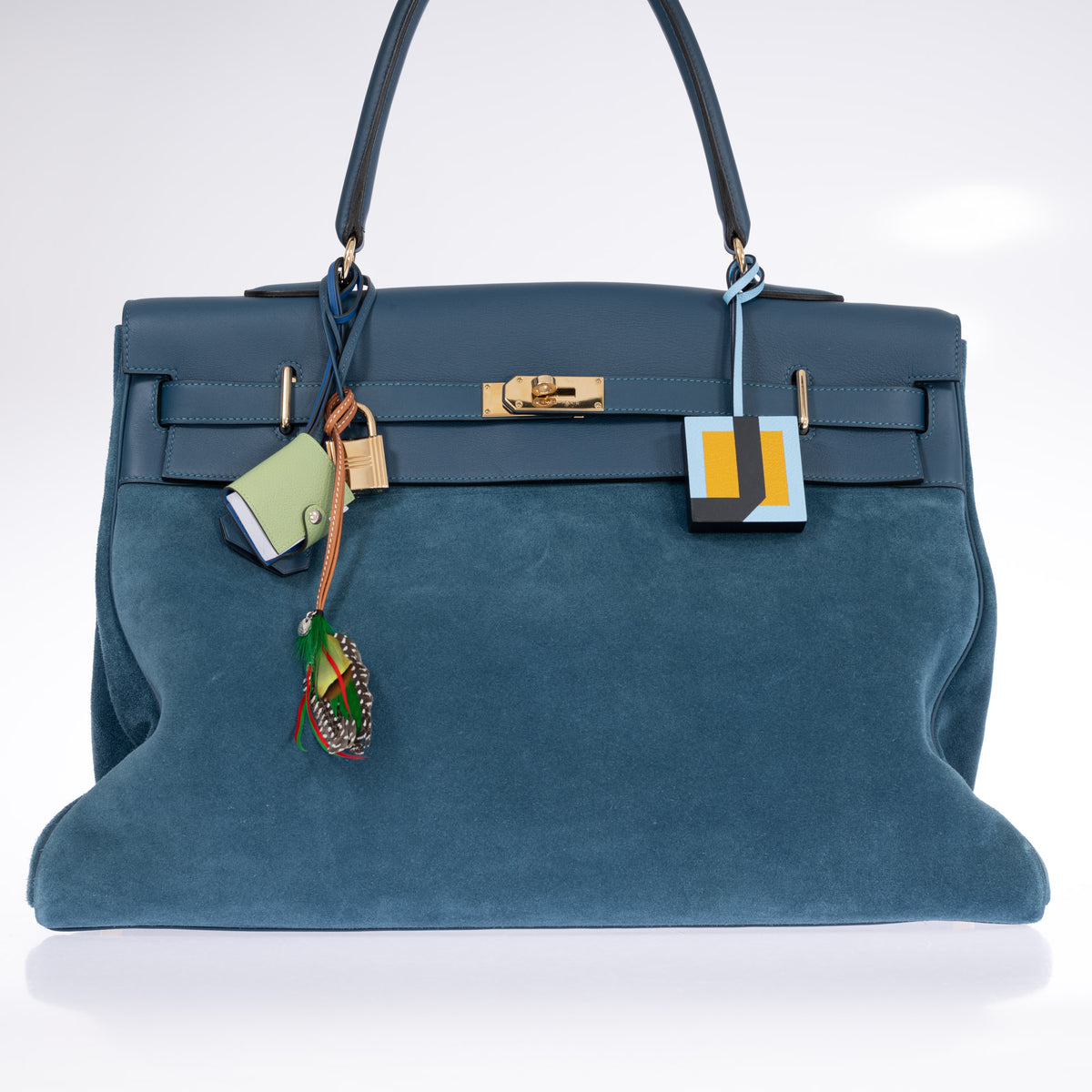 Hermès Kelly Relax 50 Grizzly Bleu Thalassa Doblis Suede and Swift Permabrass Hardware, front view of the Swift flap, sangle and turn-lock, styled with charms, sold separately