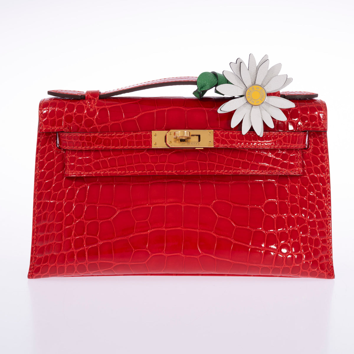 Hermès Marguerite Daisy Charm White Jaune de Naples Bambou, on the handle of a shiny alligator Kelly Pochette, bag sold separately
