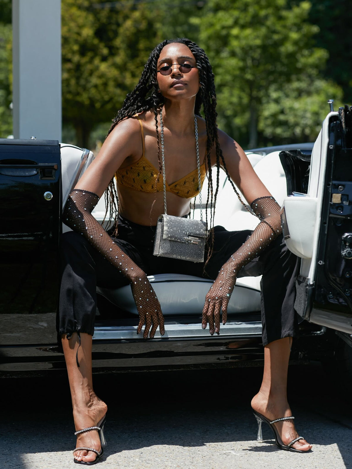 Hermès Mini Verrou Chain 18 Ombre Lizard Palladium Hardware, worn on a chain by a model seated in a car, wide view