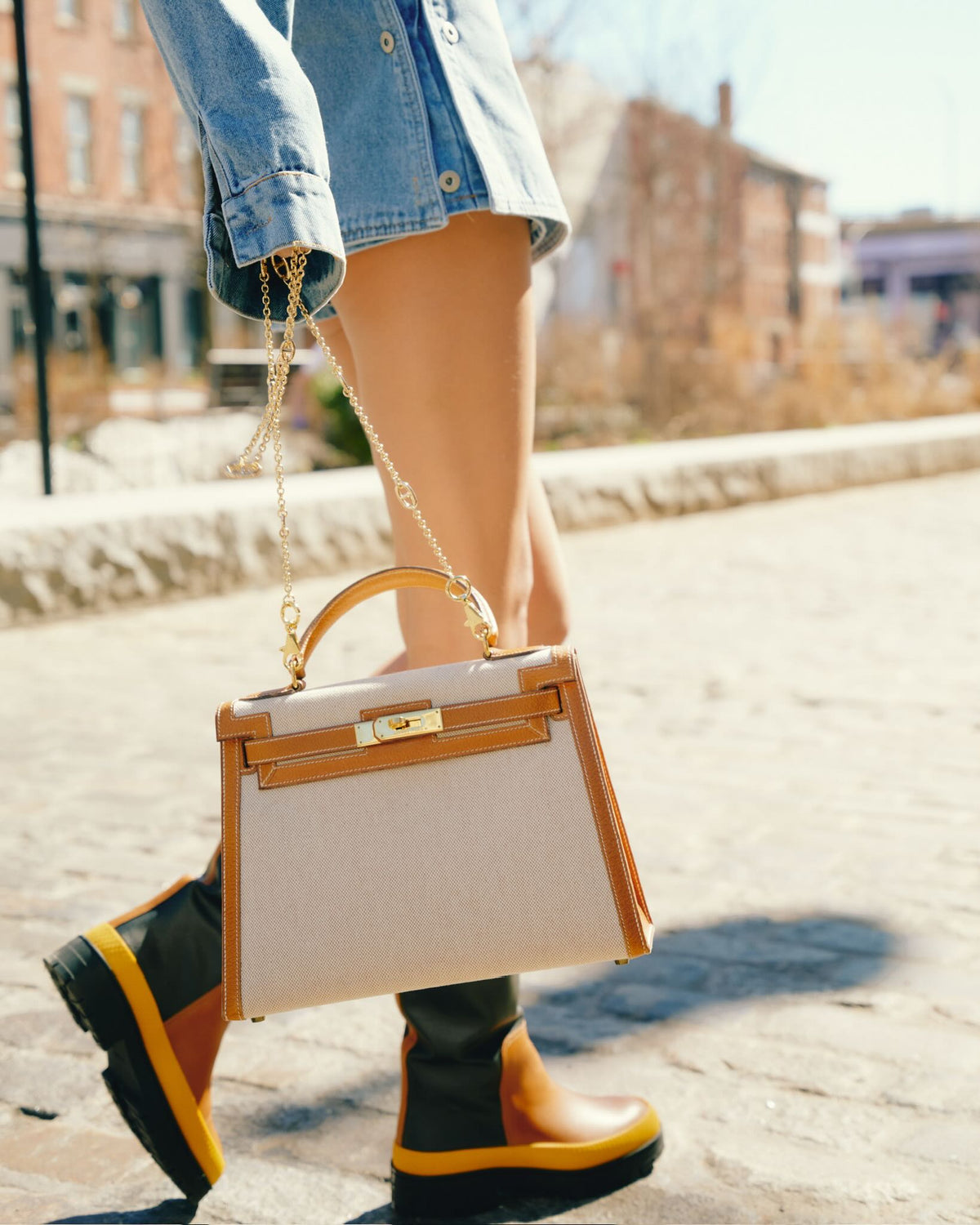 Vintage Hermès Kelly 28 Sellier Naturel and Écru Toile H and Peau Porc Gold Hardware, carried on a chain by a model, side view
