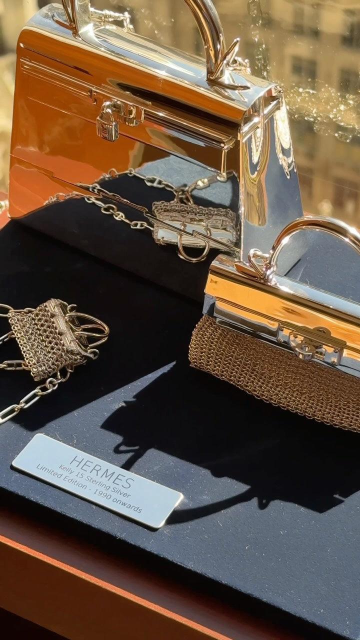 Hermès sterling silver pieces in a display case